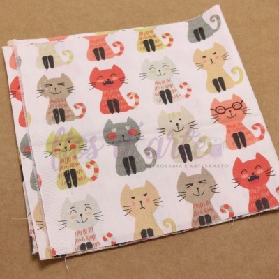 Pano de tecido branco com padrão de gatos coloridos sobre superfície castanha