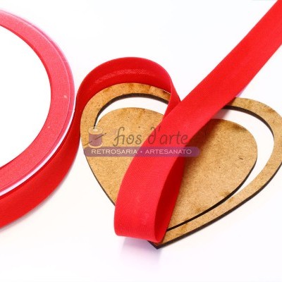 Fita de tecido vermelha enrolada num suporte em forma de coração com texto 'flos d'arte'