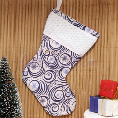 Meia de Natal branca e azul pendurada com árvore de Natal pequena e presentes coloridos