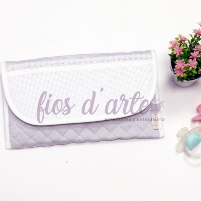 Carteira pequena em tecido cinzento com aba branca e flores ao lado