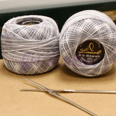 Dois novelos de linha branca com etiquetas da marca 'Helen' e duas agulhas metálicas de croché