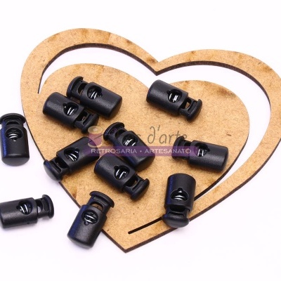 Fechos de aperto preto em plástico sobre base de madeira em forma de coração.