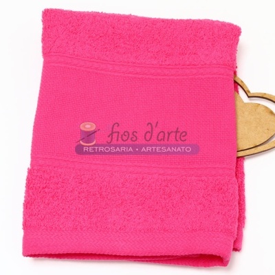 Toalha de banho vermelha com etiqueta e coração de madeira ao lado