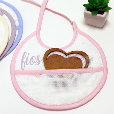 Babete de bebé rosa com bolso de malha e coração de madeira