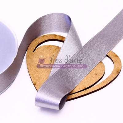 Fita de tecido prateada e base de madeira em forma de coração com texto