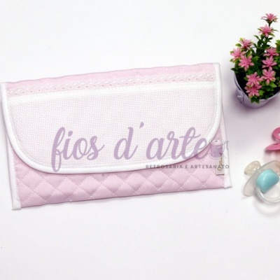 Bolsa organizadora para bebé rosa e branca, duas chupetas coloridas e vaso com flores cor-de-rosa