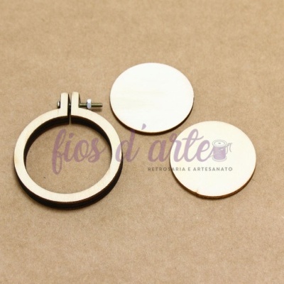 Suporte e círculos de madeira para bordado sobre fundo castanho claro com texto