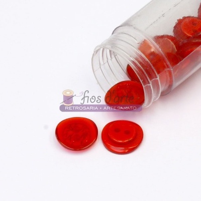 Frasco com botões vermelhos e etiqueta 'fios Artes'.