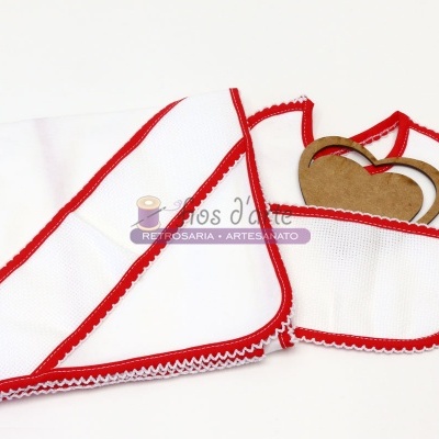 Toalha e babete brancos com bordas vermelhas, textura de ponto cruz