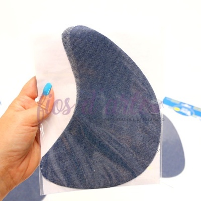 Suporte de ombro preto texturizado segurado por uma mão, com pacotes azuis e brancos ao fundo sobre superfície branca.