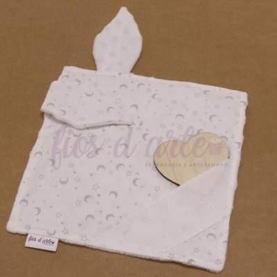 Produto têxtil branco com padrão de luas e estrelas cinzentas e ponta em nó
