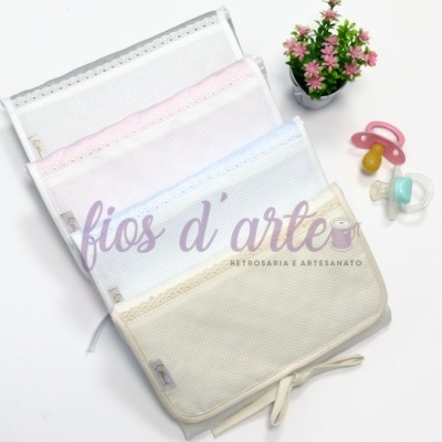 Bolsas organizadoras de tecido coloridas, chupetas e vaso com flores sobre fundo branco