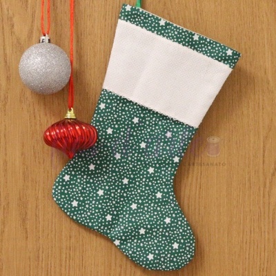 Meia de Natal verde com estrelas brancas e decorações penduradas