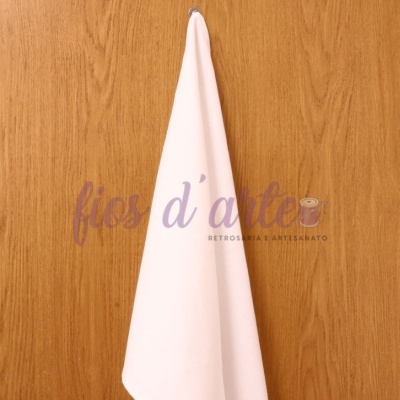 Toalha branca pendurada numa parede de madeira clara