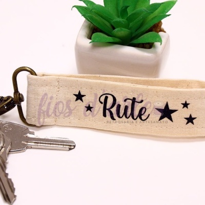 Chaveiro tecido bege com texto e estrelas, chaves e planta artificial