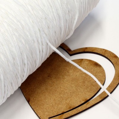 Rolo de fio branco enrolado numa base em forma de coração.