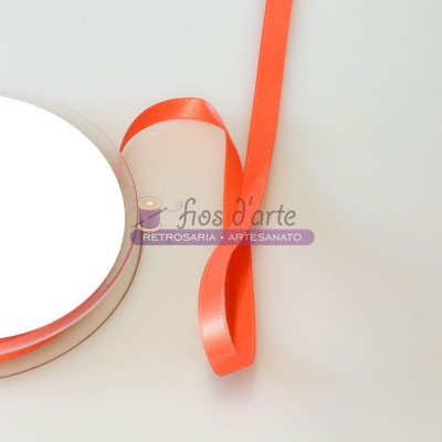 Carretel de fita de cetim laranja sobre superfície branca