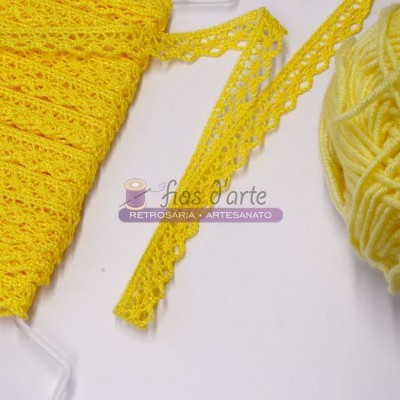 Fita rendada amarela e novelo de lã amarelo com etiqueta sobre fundo branco