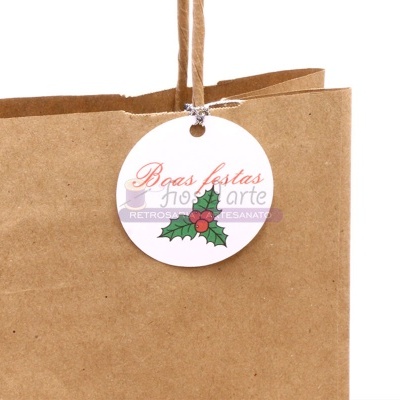 Saco de papel castanho com etiqueta de boas festas e desenho de folhas e bagas