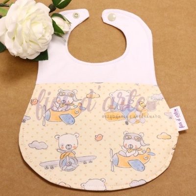 Babete de tecido com padrão de ursos em aviões em tons pastel