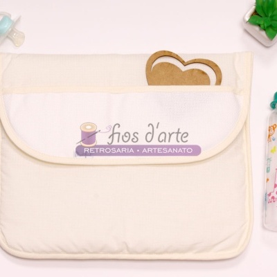 Bolsa cremosa em tecido com chupeta azul, biberão com desenhos e planta artificial