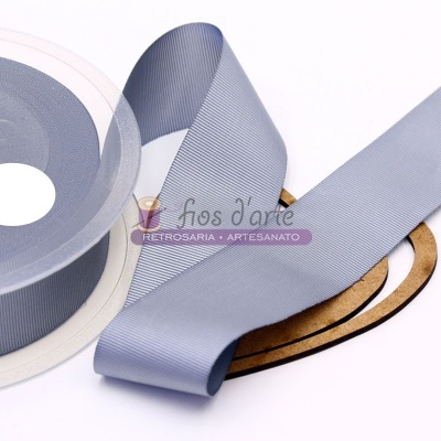 Rolo de fita de tecido cinzento claro sobre suporte branco e base de madeira em forma de coração