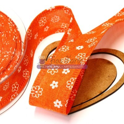 Fita de tecido laranja com flores brancas enrolada em carretéis