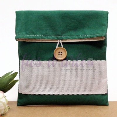 Bolsa de tecido verde com botão de madeira e faixa branca decorativa