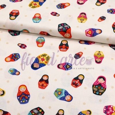 Tecido branco com bonecas russas coloridas estampadas.