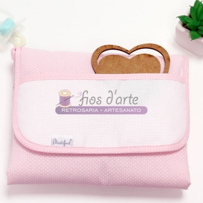 Nécessaire cor-de-rosa com tampa branca, texto 'fios d'arte', forma de pão de madeira, biberão e planta