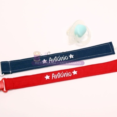 Duas fitas de chupeta personalizadas com o nome António e uma chupeta azul clara