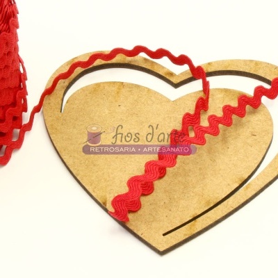 Fita vermelha ondulada sobre base de madeira em formato de coração com logótipo