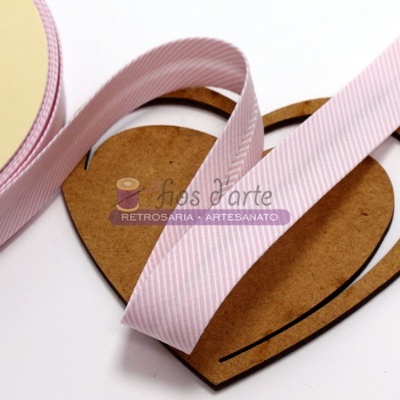 Fita rosa com riscas brancas em carretel ao lado de moldes coração de papelão