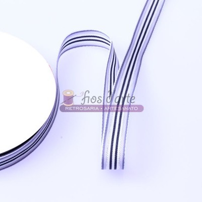 Fita branca com riscas pretas enrolada num carretel sobre fundo branco