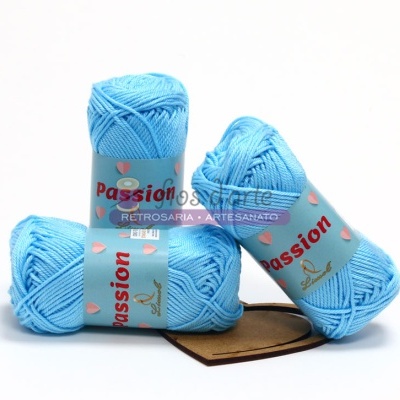 Três novelos de lã azul clara com etiquetas azuis claras 'Passion'