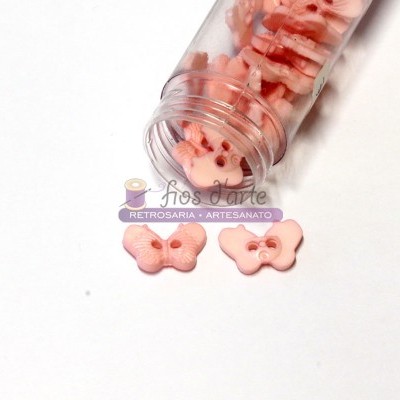 botões de borboleta cor-de-rosa em frasco plástico transparente e superfície branca
