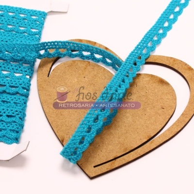 Fita de renda azul turquesa sobre cartão e coração de madeira