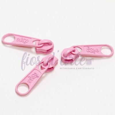 Três pegas de fecho éclair cor-de-rosa sobre fundo branco com texto parcial