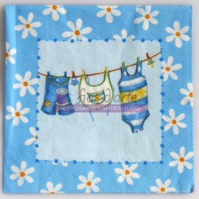 Guardanapo azul com margaridas brancas e ilustração central de roupas de bebé num estendal