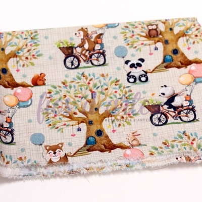 tecido infantil com padrão de árvores e animais em fundo bege claro