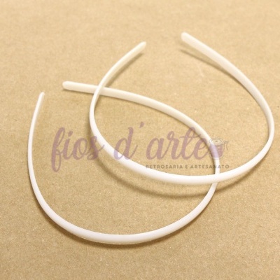 Dois arcos de cabelo brancos finos sobre fundo bege com texto sobreposto.