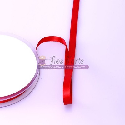 Rolo de fita de cetim vermelha em carretel sobre fundo branco