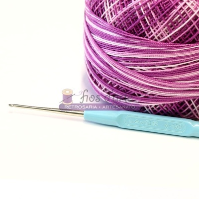 Linha de crochet rosa e lilás com agulha azul claro e fundo branco
