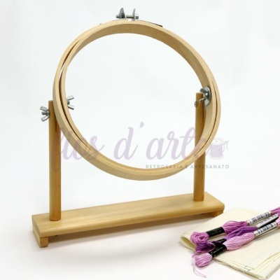 Aro de bordado em madeira com novelos de linha rosa e tecido