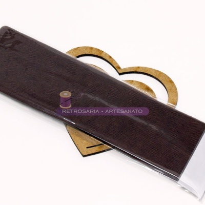 Tira de tecido castanho escuro embalada em plástico, com fundo de coração de cartão e etiqueta