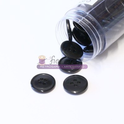 Frasco com botões pretos redondos com quatro furos sobre uma superfície branca