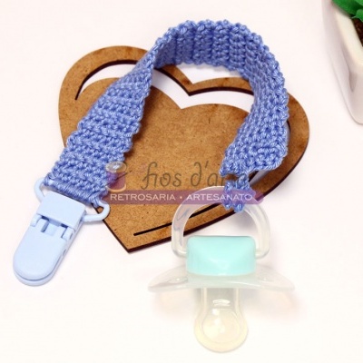 Chupeta azul clara com suporte de tecido tricotado azul e fundo de coração de madeira com texto