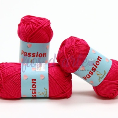 Três novelos de lã rosa com etiquetas azuis