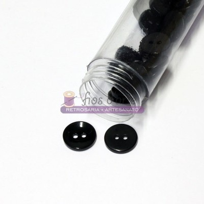 Frasco de botões pretos redondos abertos com dois botões à frente, fundo branco