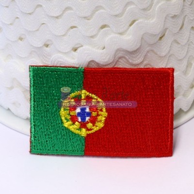 Ecusson bordado da bandeira de Portugal com verde, vermelho e brasão, sobre superfície branca ondulada